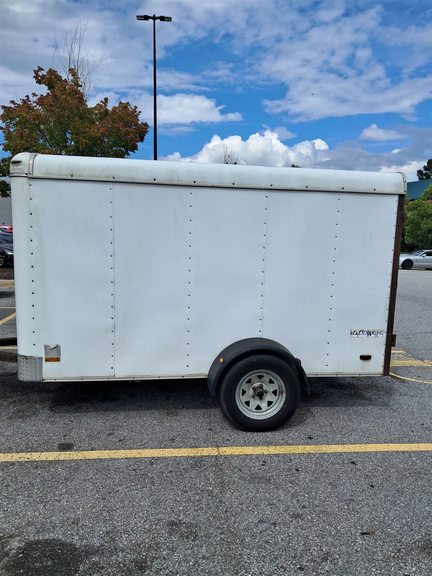 Plain white Big Woff Lawn Service utility trailer before custom graphics were installed