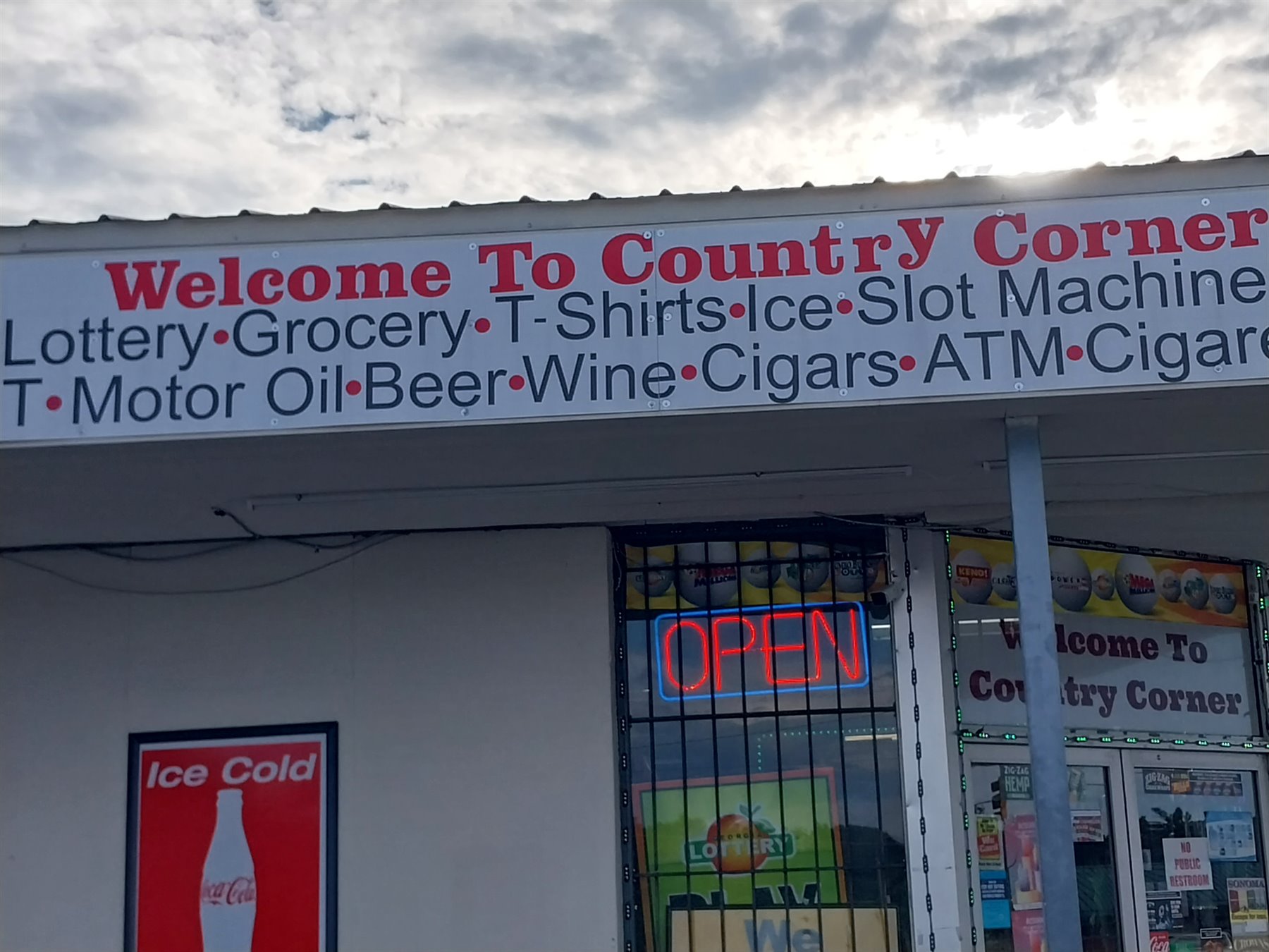 Country Corners storefront sign and window graphics with open neon sign