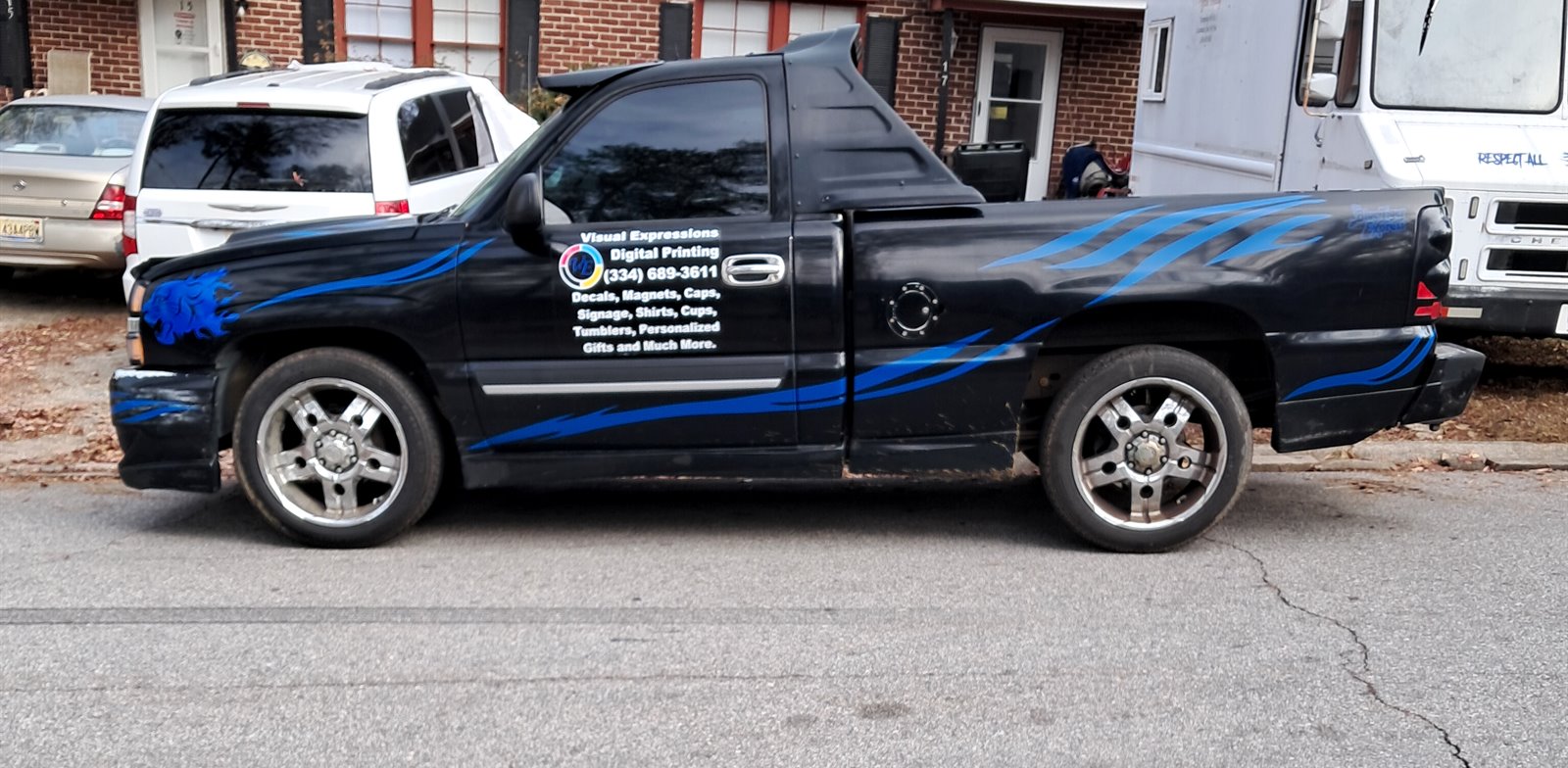 Driver side of the Visual Expressions Nasty truck with custom blue vehicle graphics and business lettering
