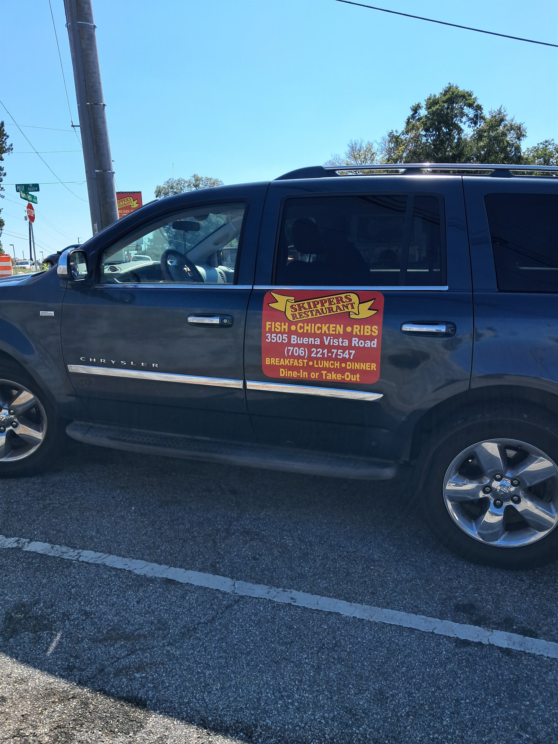 Custom Skippers Restaurant business vehicle magnet installed on a blue Chrysler